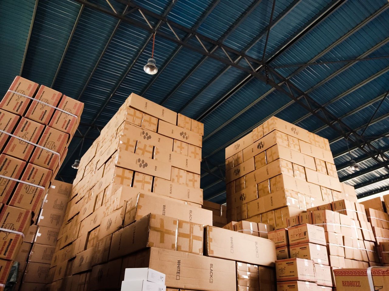 Rows of finished export cartons stacked in a warehouse awaiting shipment, where undiscovered quality fade becomes most expensive to fix