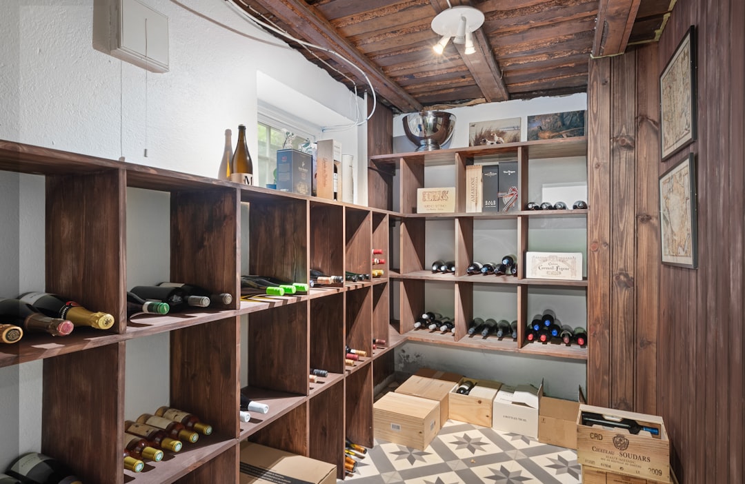Interior of a wine cooler with adjustable wooden shelves holding various wine bottles