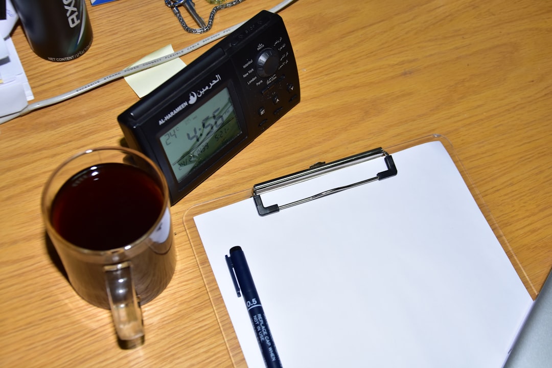 A hand adjusting the digital temperature controls on a dual-zone wine cooler.