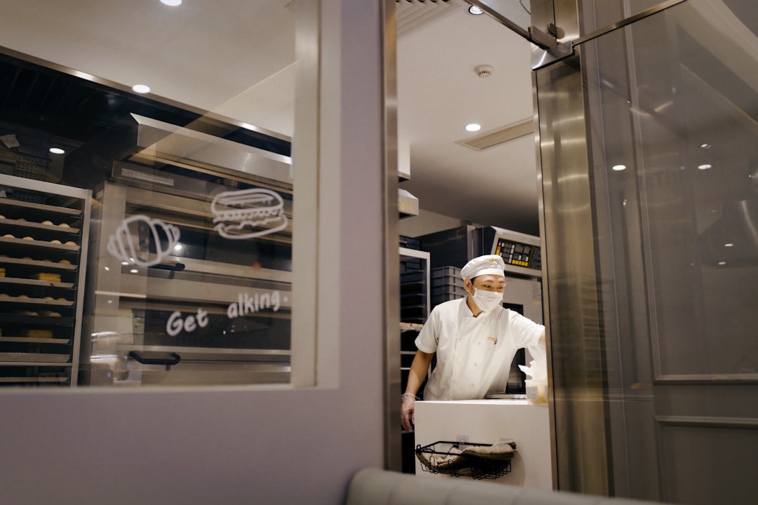 A chef inspecting different cuts of meat in a large dry aging cabinet