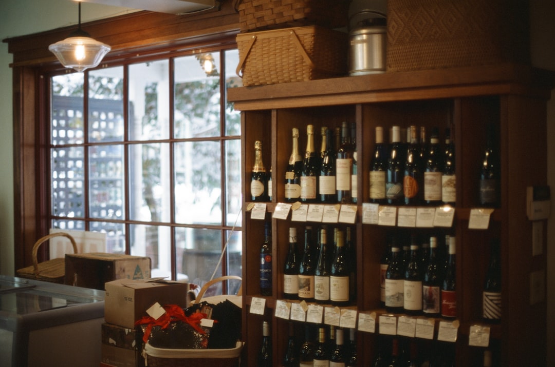 A collection of red and white wine bottles resting on wooden shelves inside a cooler