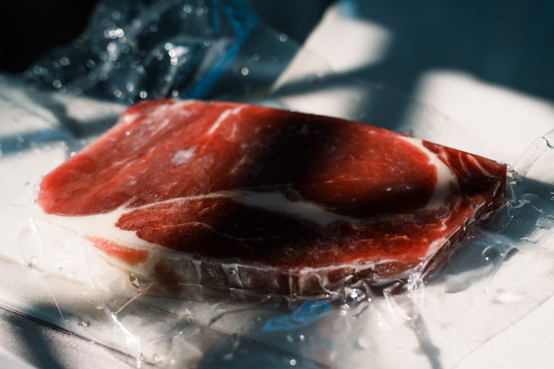 A large, beautiful cut of marbled beef aging inside a glass-door dry ager fridge.