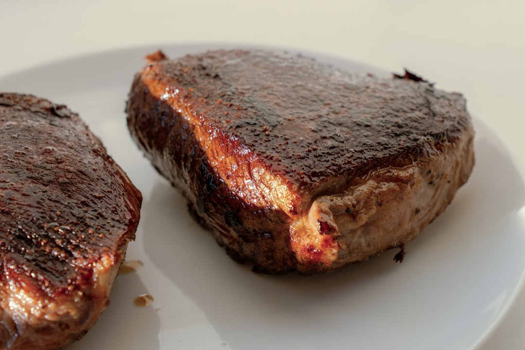 A side-by-side view showing the whole aged subprimal with its dark pellicle and the vibrant red, trimmed steaks ready for cooking.