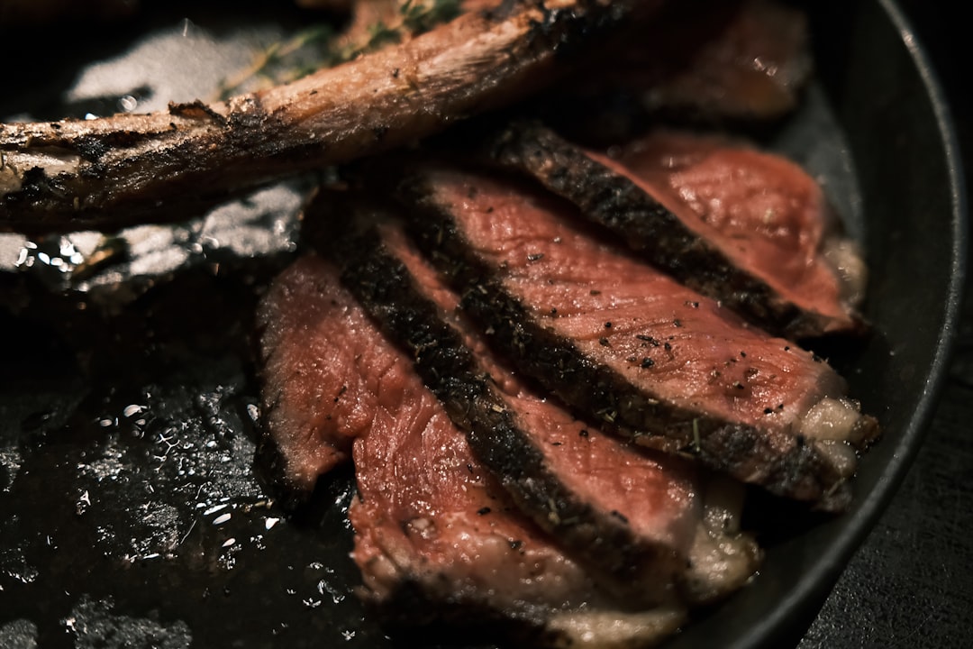 A close-up shot of a thick, perfectly seared dry-aged steak, sliced to show the red interior.