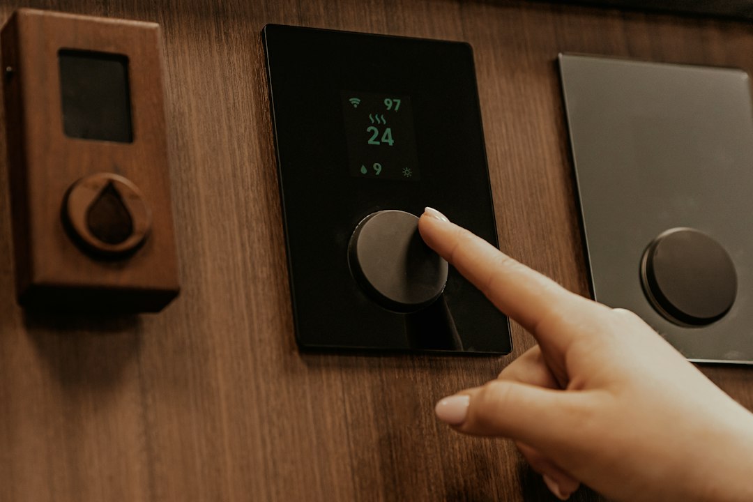 A hand adjusting the temperature on a dual-zone wine cooler digital display