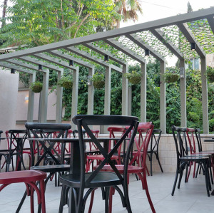 La terrasse extérieure d'hôtel de meubles de chaise latérale en métal croisent les chaises de salle à manger de café de conception de dos