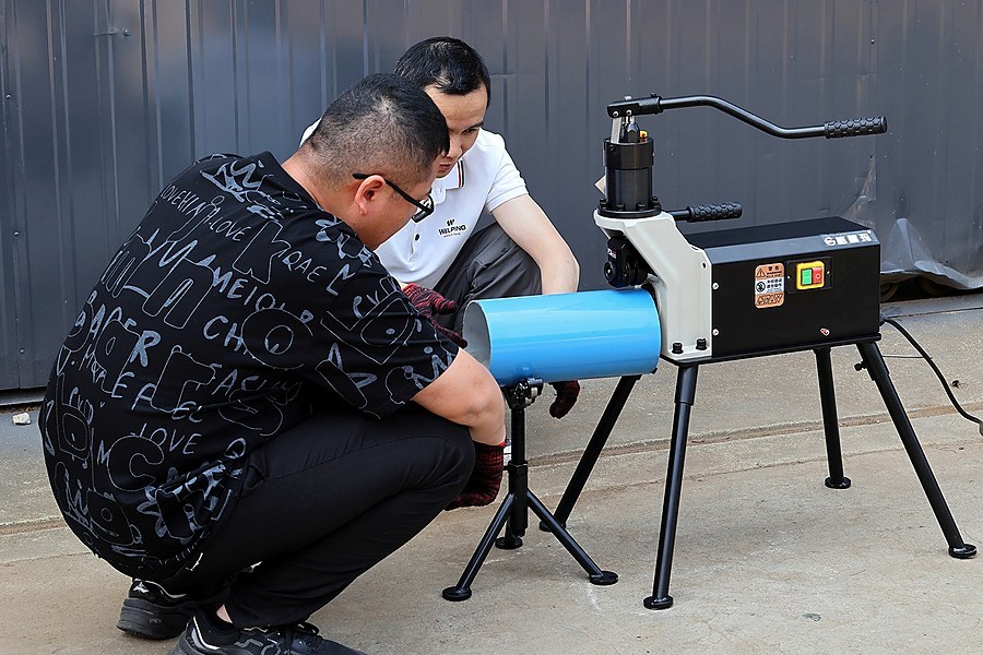 WELPING technicians demonstrating the RG-2T roll grooving machine