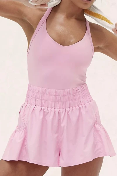Sporty jumpsuit features a fitted top, loose fitting bottoms, short length, and slip-on design
