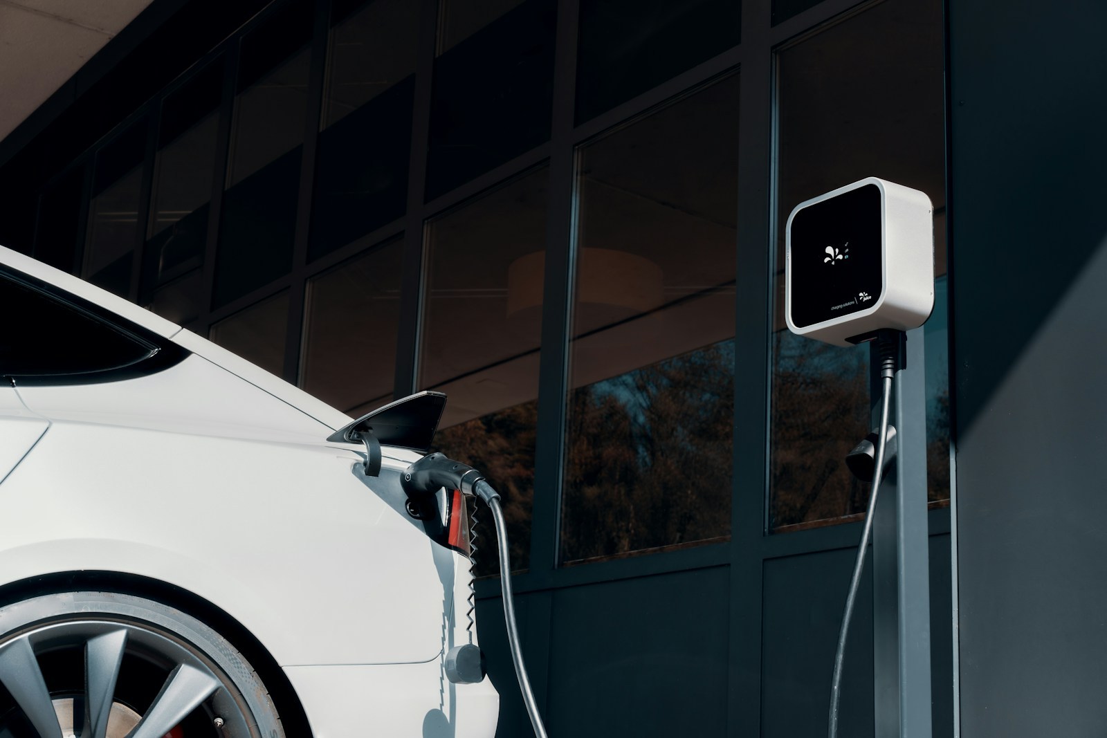 White electric car plugged into a public charger