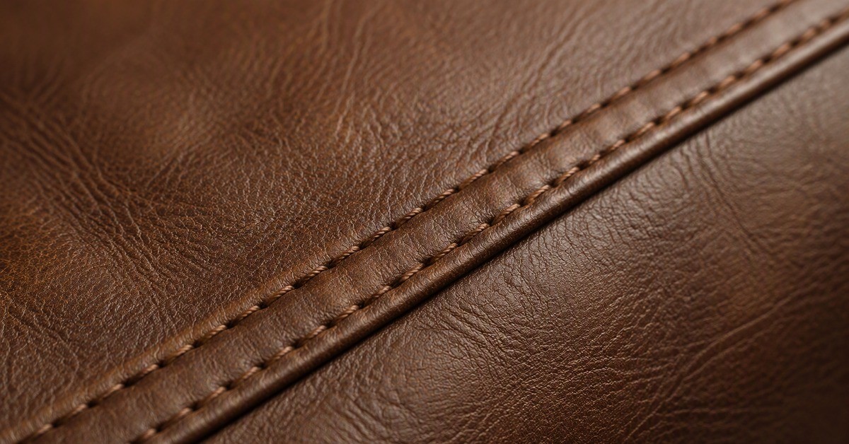 Close-up of the shoulder yoke and topstitching on a brown leather jacket, the article tested under REACH entry 77.