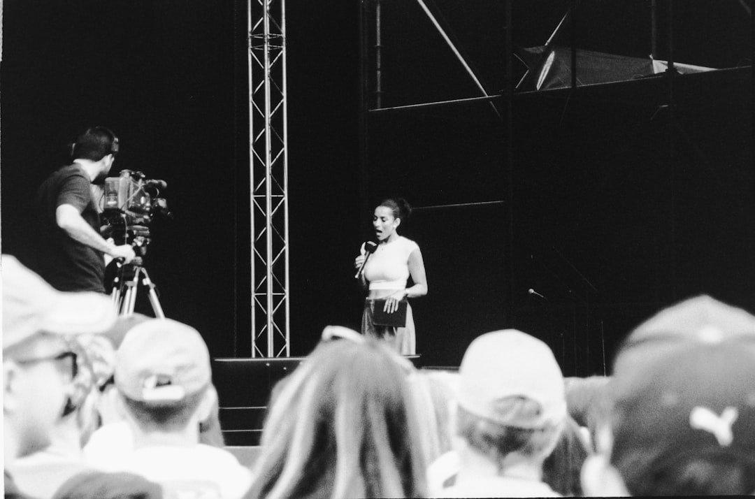 A musician setting up an active PA speaker on a stage.