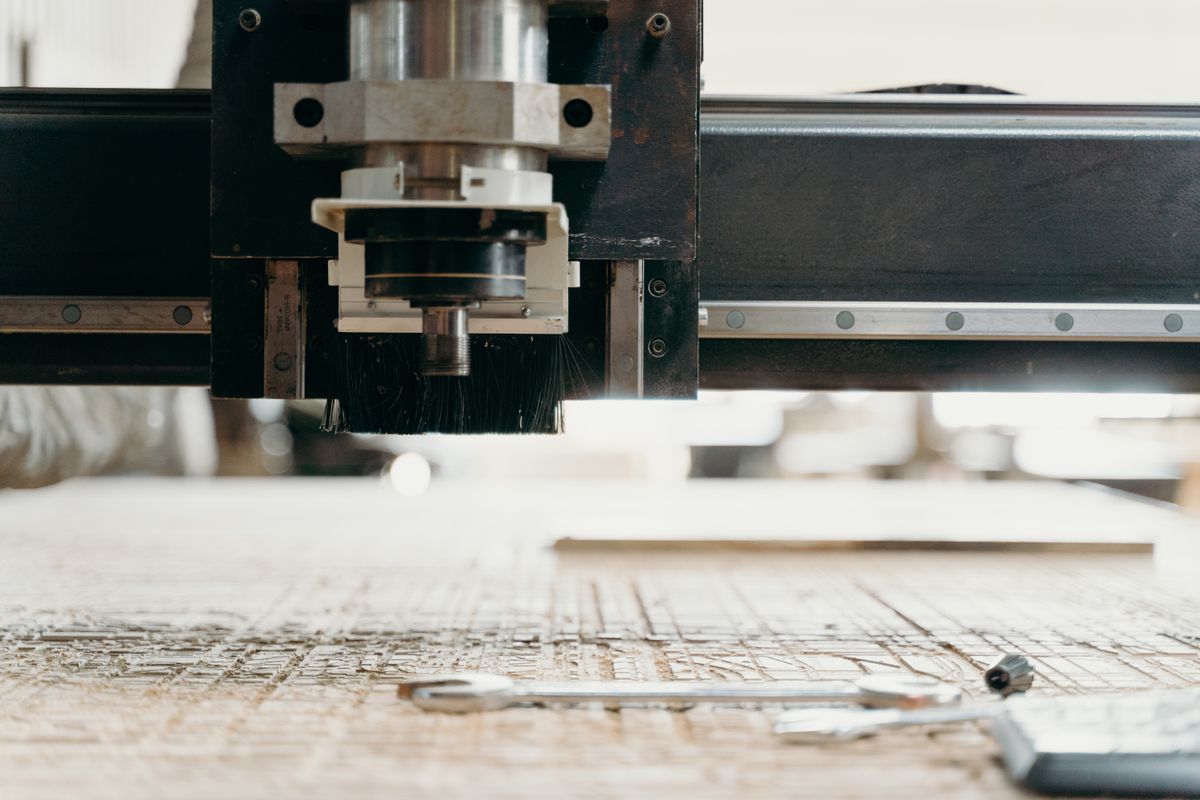 Close-up of a CNC machining centre spindle and linear rail above a workpiece