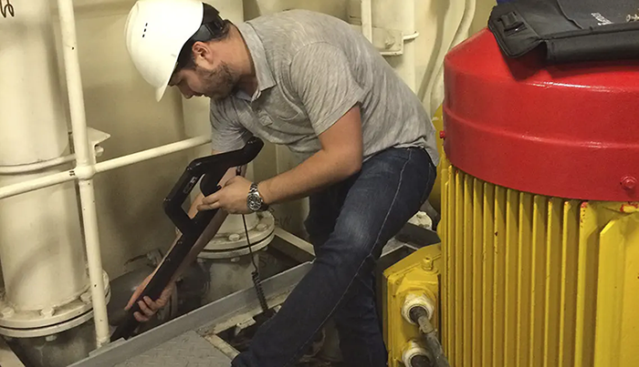 Operators use a manually operated 3D measurement system to measure the dimensions of large industrial equipment supports.