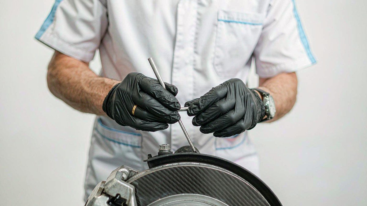 Mechanic installing brake pads on a car brake disc