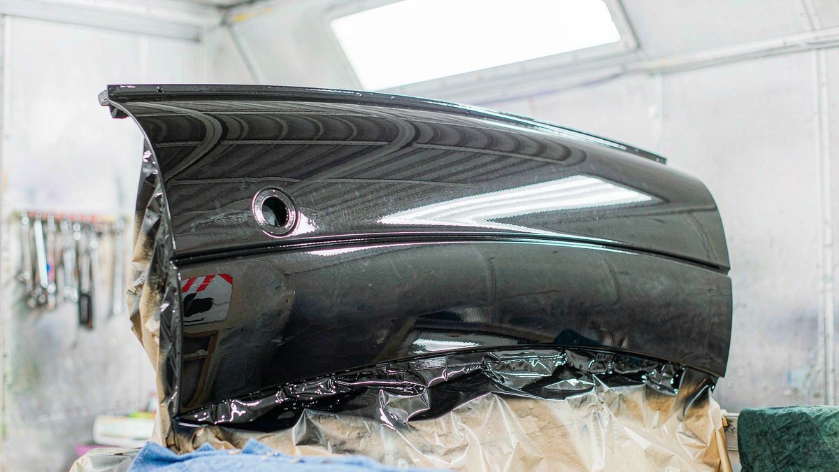 Repaired car fender being refinished in a body shop