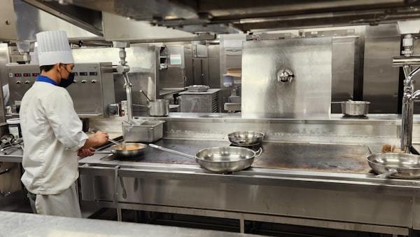Chef preparing food on a gas stove in a compact commercial cooking space