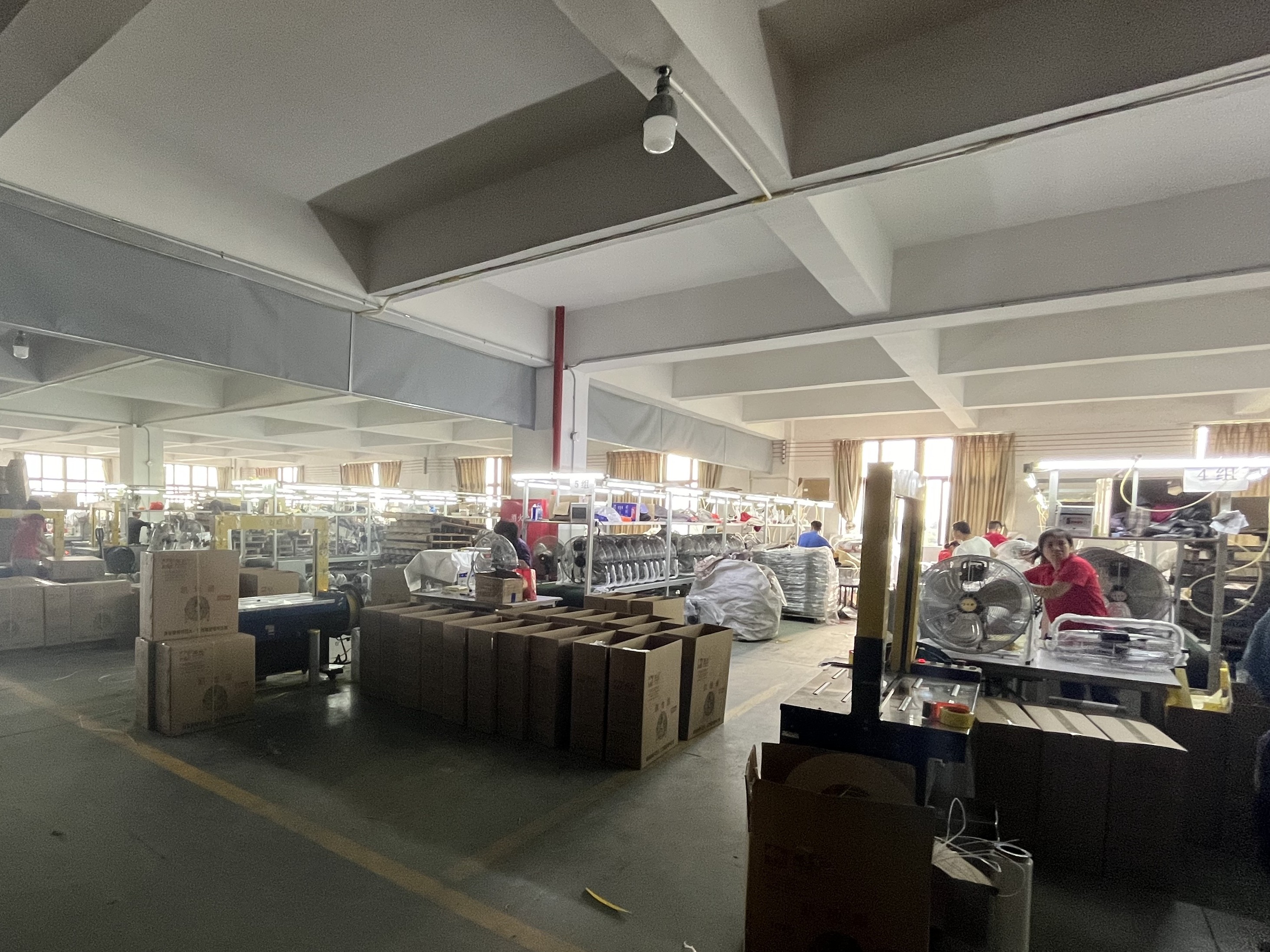 A durable commercial electric floor fan in a workshop setting