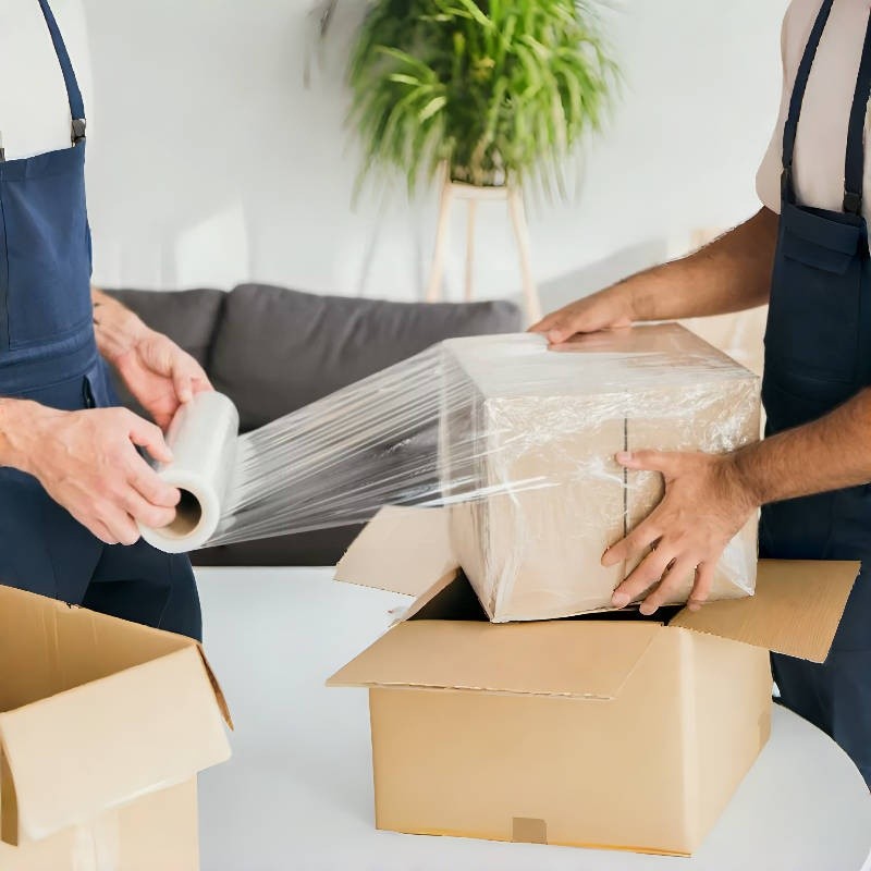 Person using Handheld Stretch Film to wrap boxes for home or small business shipping needs