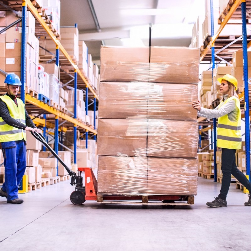 Workers safely carry palletized goods wrapped in stretch film