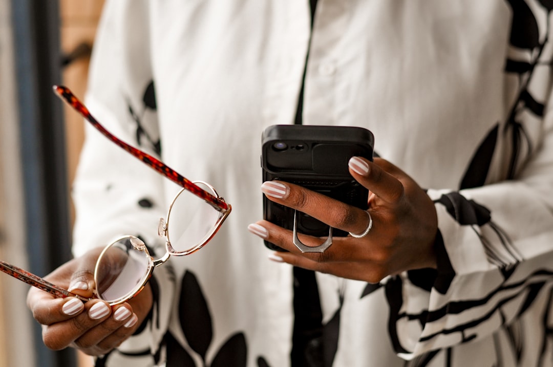 A person using a smartphone app to adjust their wine cooler's temperature
