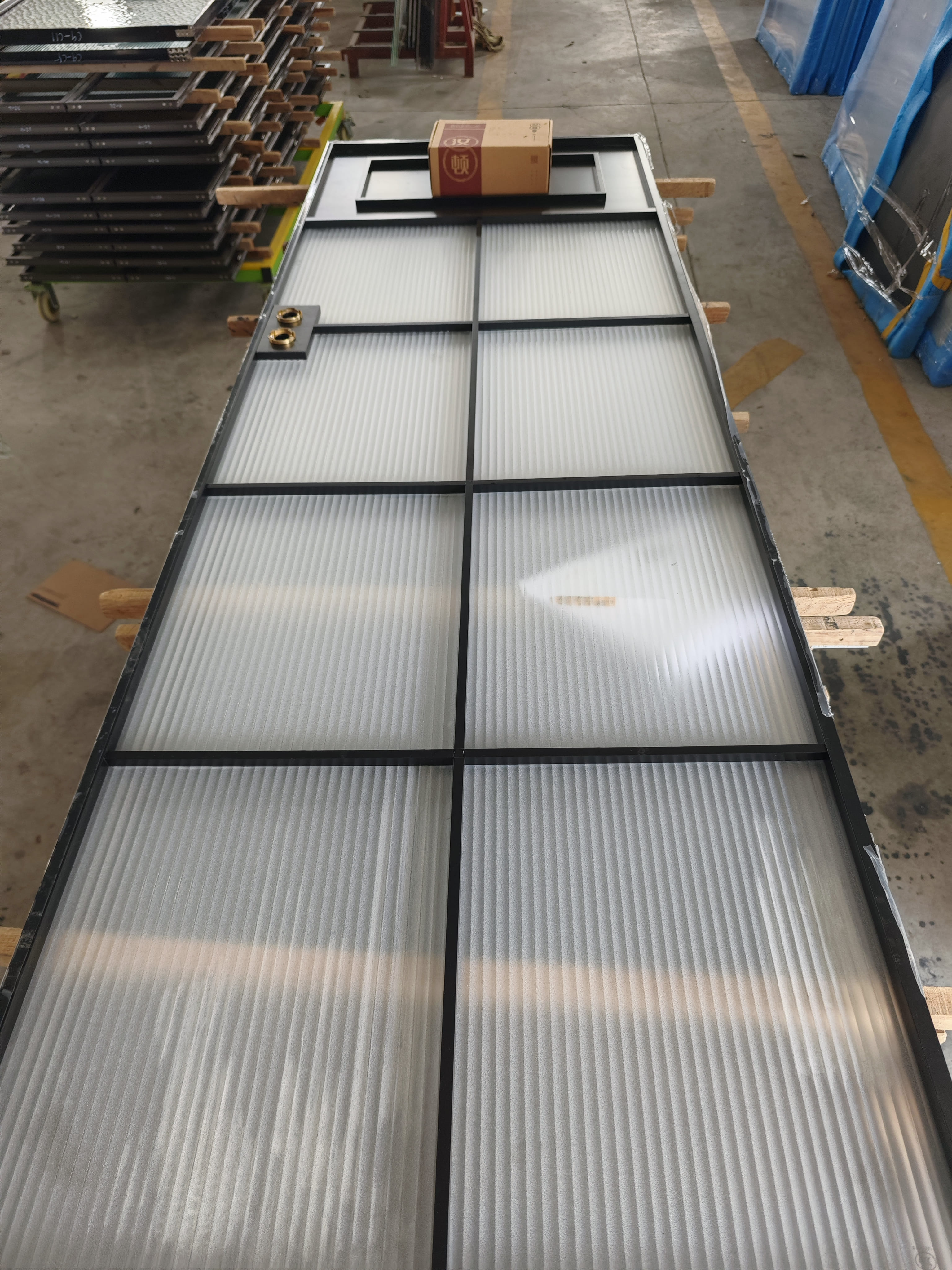 Porte moderne en aluminium avec verre nervuré dépoli