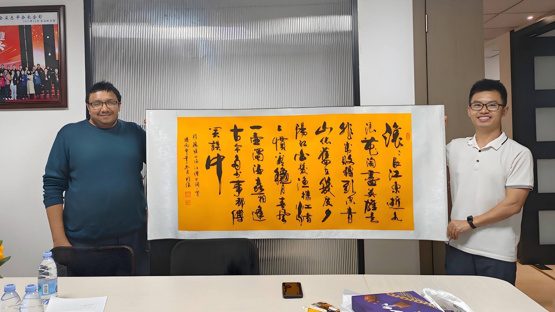 BLOSSOM CHEER business manager David presenting a calligraphy artwork as a gift to a visiting UK client during the showroom visit