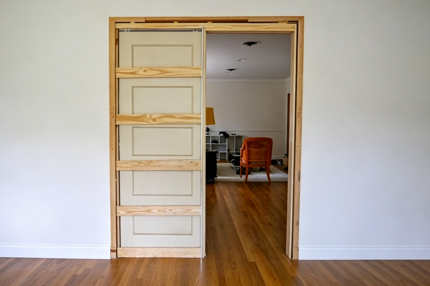 Opened wall exposing studs and service lines for pocket door installation