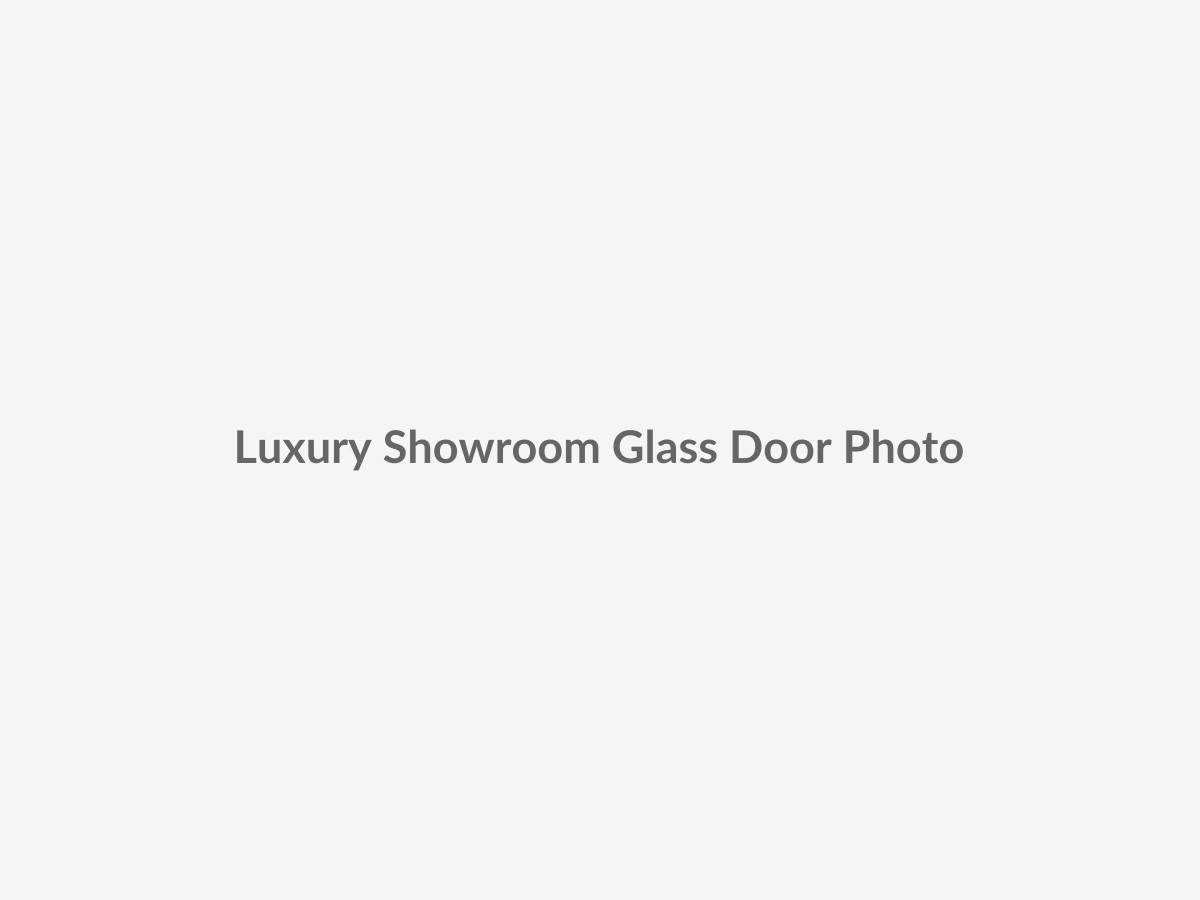 Real-life showroom photography placeholder showing a full-view aluminum glass garage door in a luxury supercar display space with large transparent glazing and a high-end architectural facade