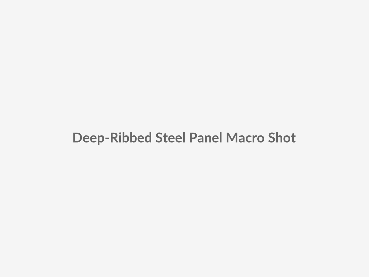 High-resolution macro placeholder showing deep-drawn longitudinal ribbing and coated heavy-gauge steel panel texture used in commercial sectional steel doors