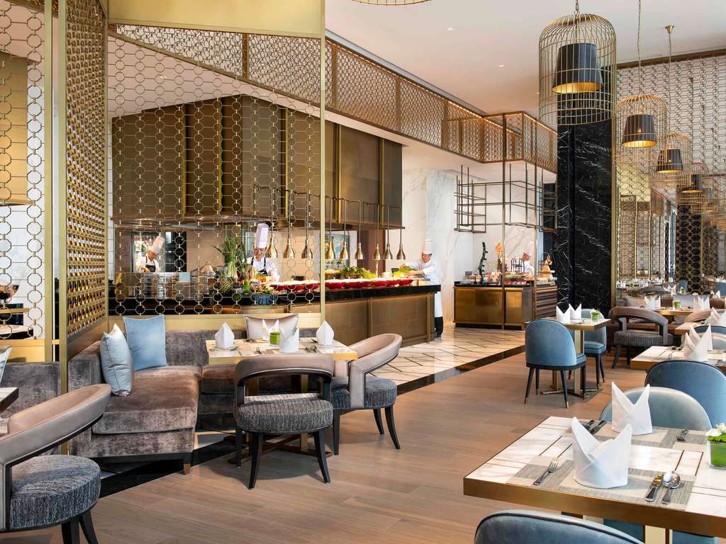 hotel breakfast buffet with various food stations and chafing dishes