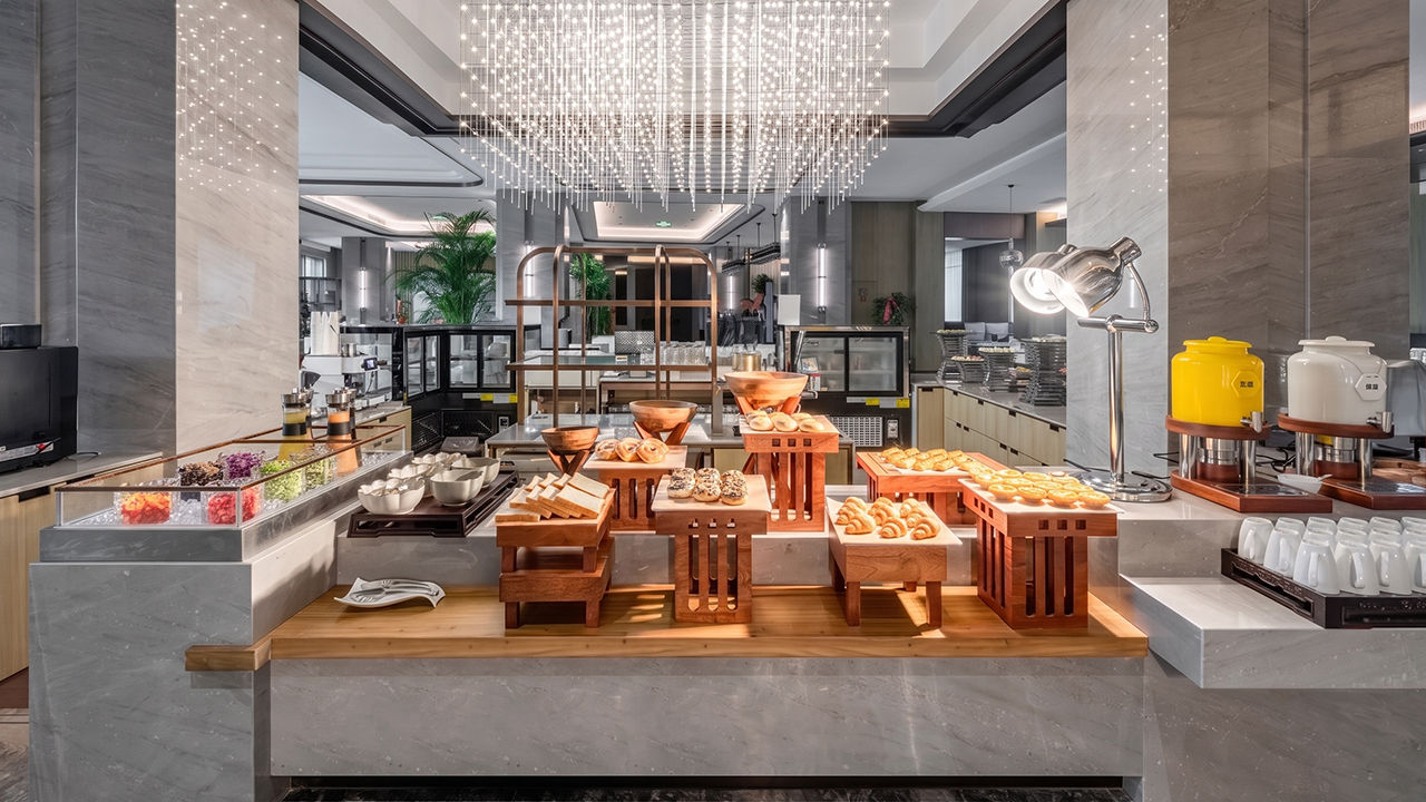 Five-star hotel breakfast buffet line with hot food stations and bakery displays