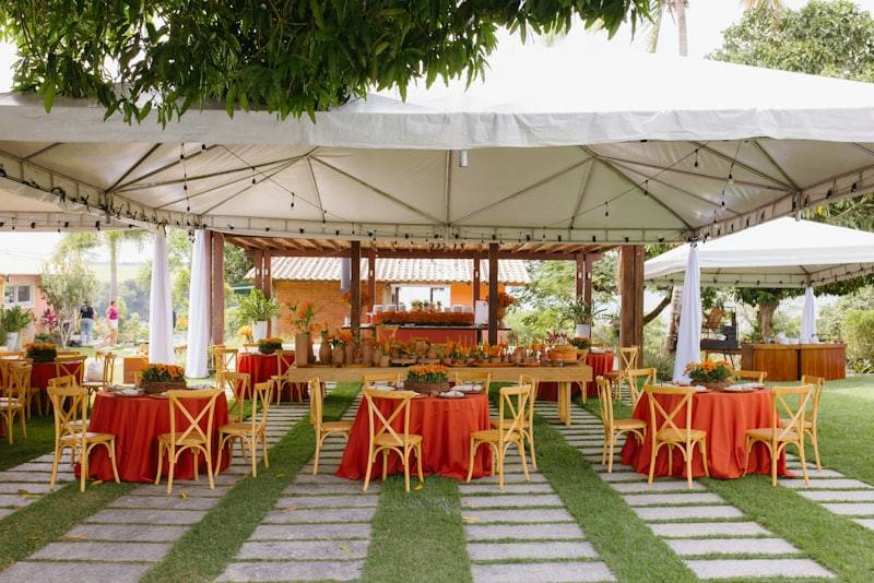 Outdoor catering event under a white tent with set buffet tables
