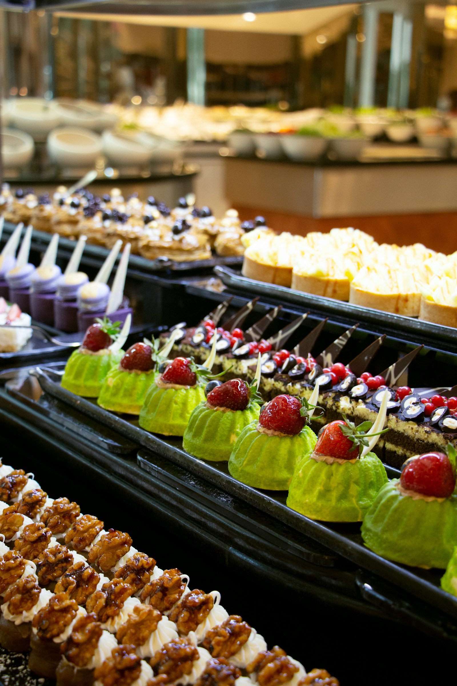 Dessert buffet display with items arranged at multiple heights on stands