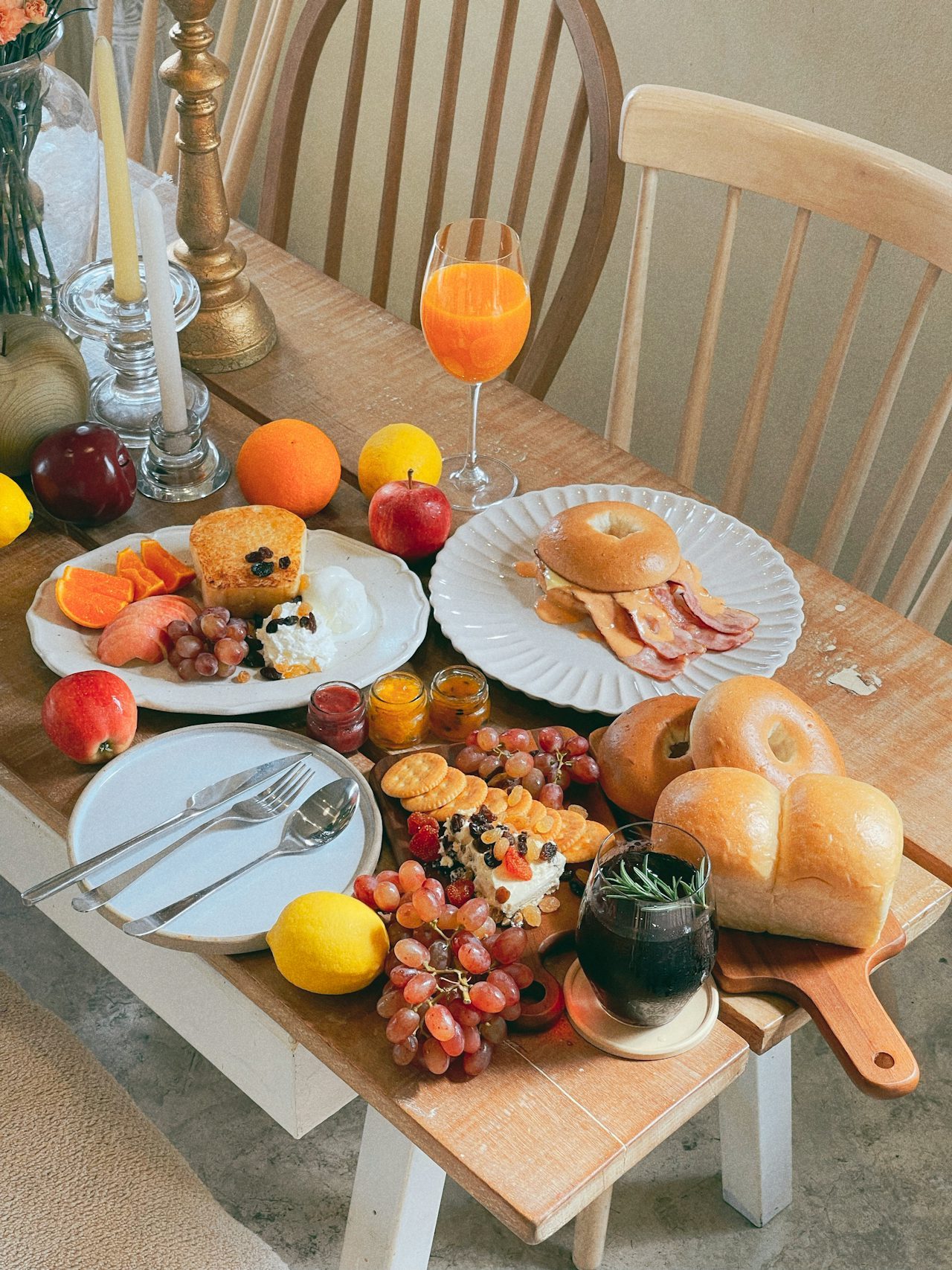 A breakfast spread with juice, bread, fruit and condiments laid out for service