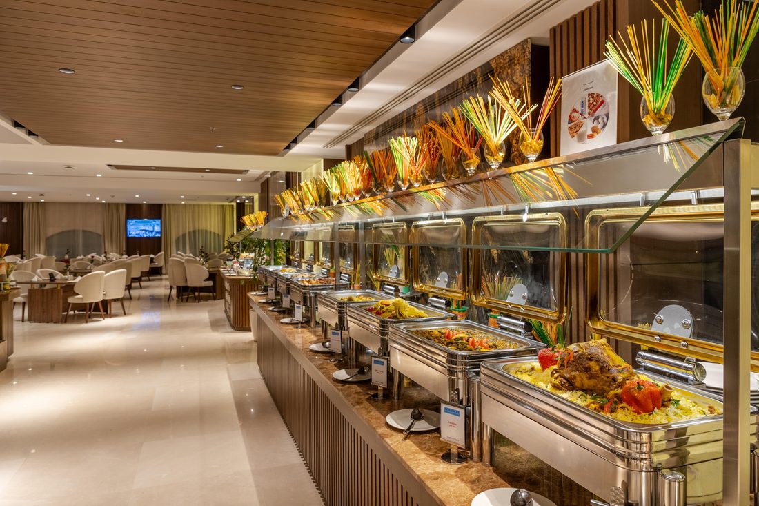 Full size chafing dish line with gold chafing dishes and glass sneeze guards at a five-star hotel buffet