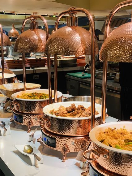 Chafing dish full size and chafing dish large copper hammered pans filled with food at a banquet buffet service