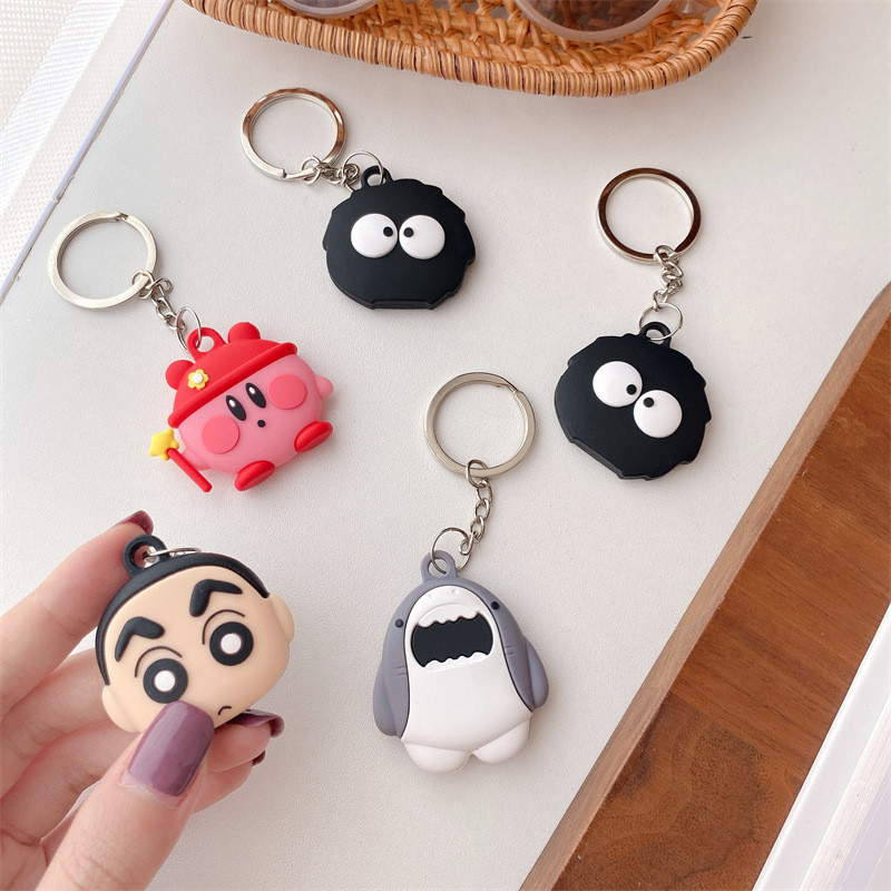 Custom 3D silicone character pendants and keychain charms placed on a wooden desk