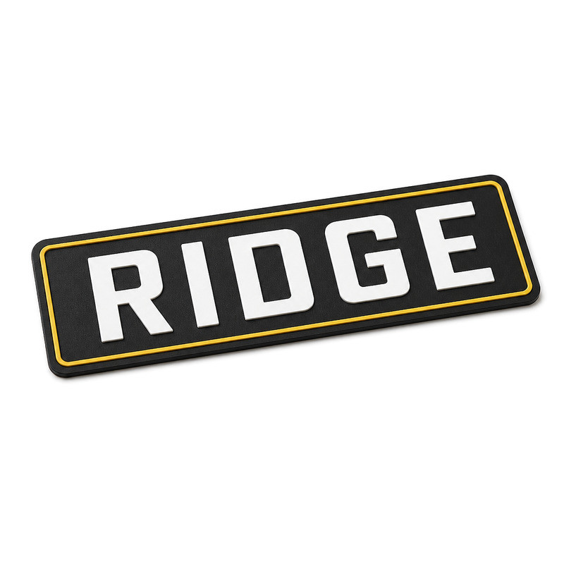 Embossed silicone labels with raised wordmark ridge showing relief height and base thickness