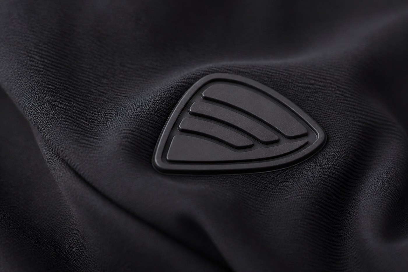 Silicone patch flexing with black four-way stretch sportswear fabric while the fabric is pulled
