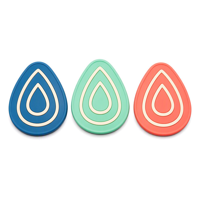 Three teardrop shaped silicone labels with rounded edges and concentric raised lines, showing edge geometry suited to knit fabrics