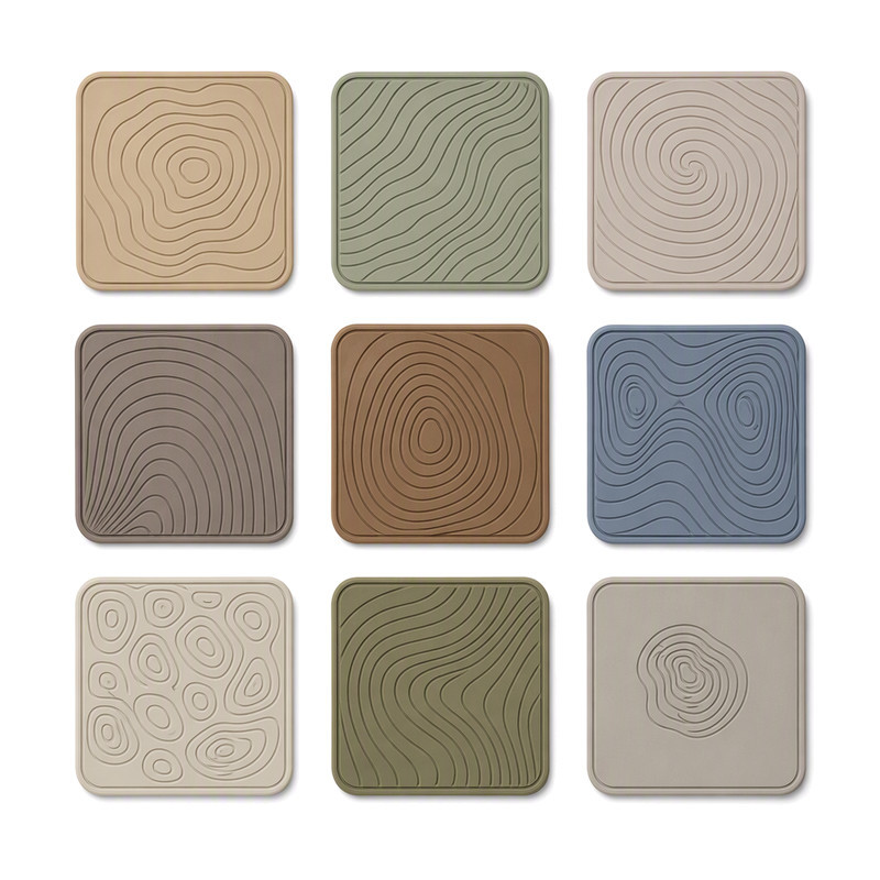 Nine square silicone patches with fine raised contour line patterns, showing shallow relief detail for stretch sportswear