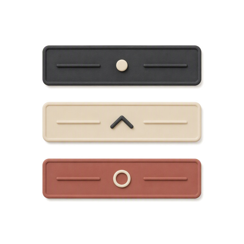 Slim silicone transfer label bars with a centred raised motif and flanking raised lines on matte surfaces