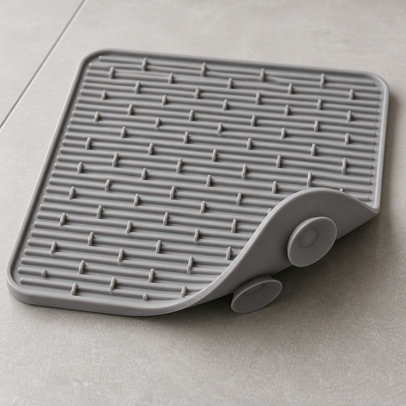 Dove grey silicone lick mat showing its comb and baffle pattern on one side and moulded suction cups on the other
