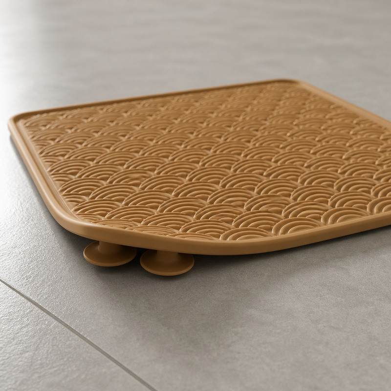 Camel coloured silicone lick mat turned over to show a thick rim, crescent shaped underside and moulded suction cups