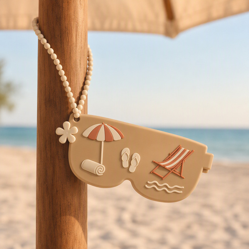 Sand coloured custom silicone sunglasses pouch hanging from a wooden beach umbrella pole