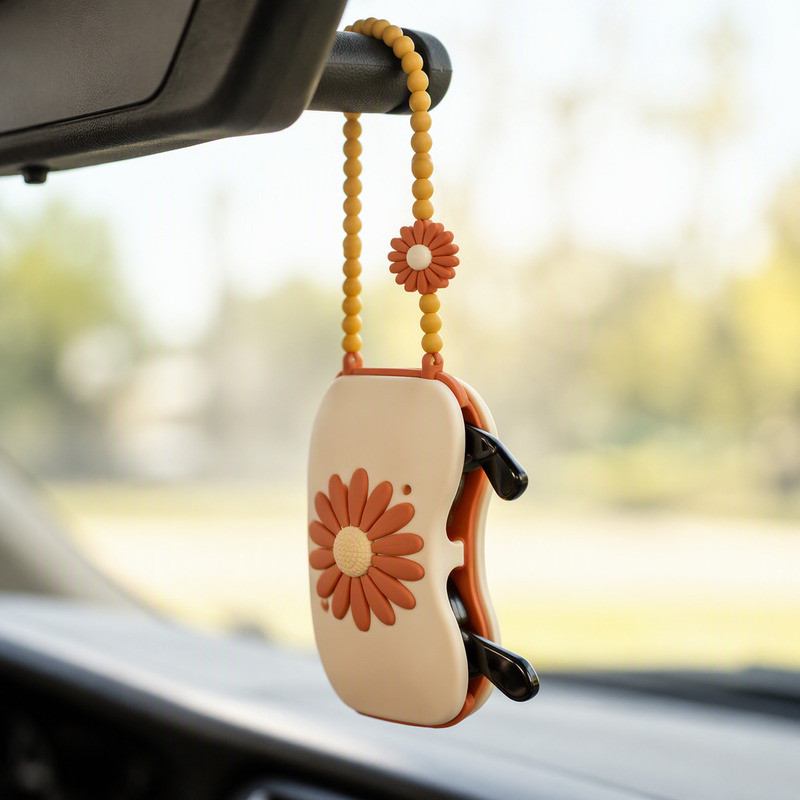 Portable silicone sunglasses case hanging from a car sun visor arm by its beaded strap