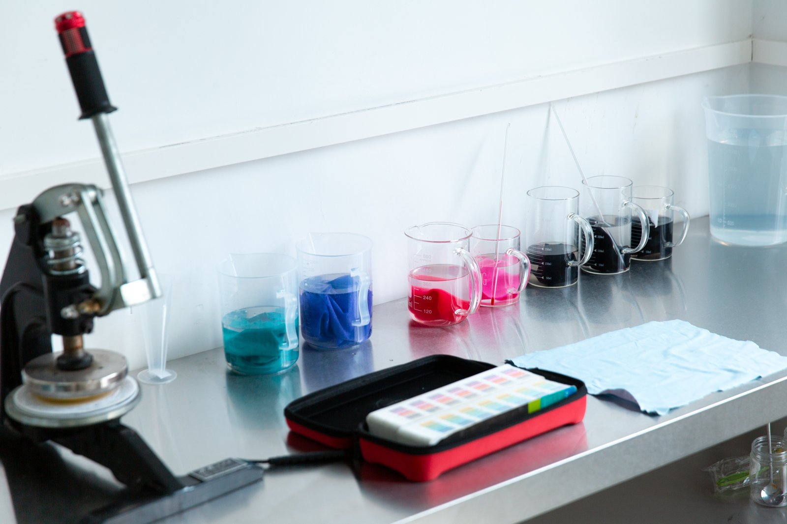 Quality inspector checking pink fabric panels under a color-matching light box in our Dongguan QC lab