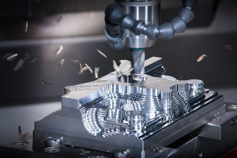 Close-up of a 5-axis CNC machine cutting a complex steel mold