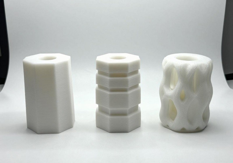 A person inspecting the surface quality and details of a 3D printed part with calipers