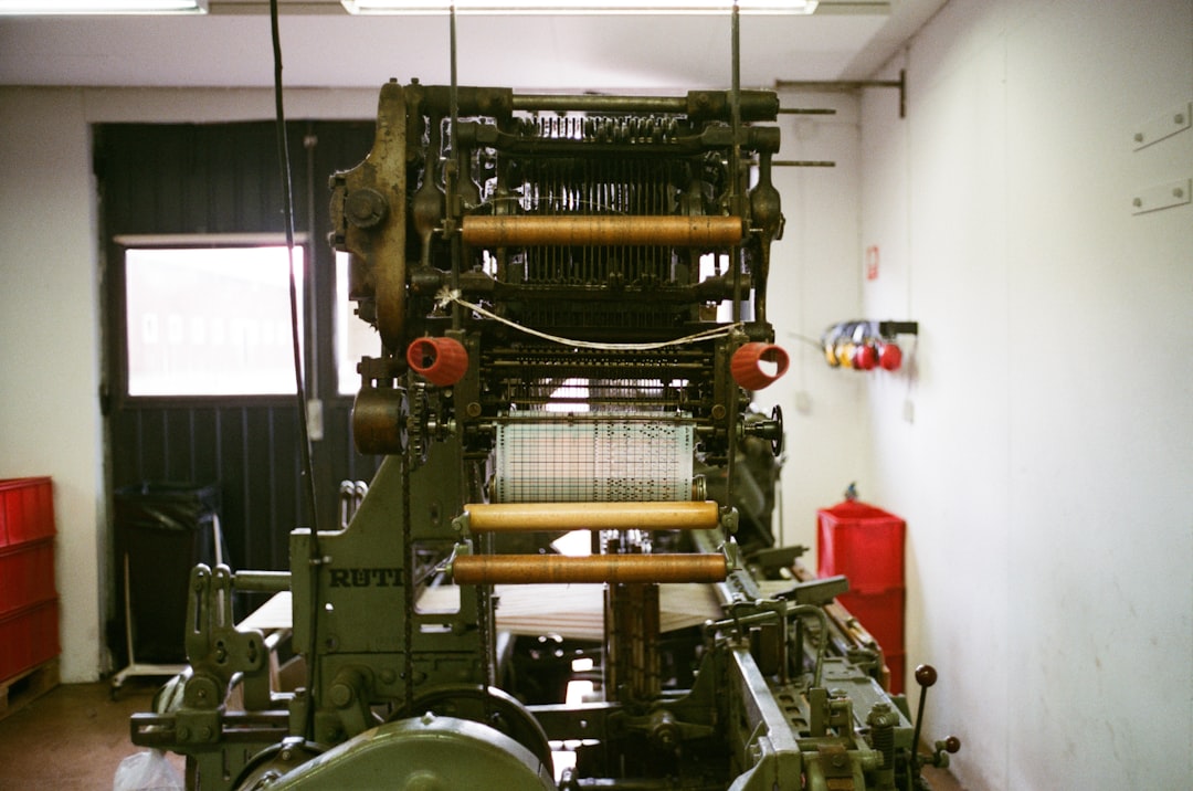A progressive die stamping machine in operation, showing the metal coil feed